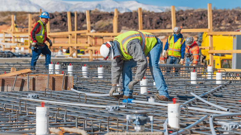 A person in a safety vest working on a construction site.