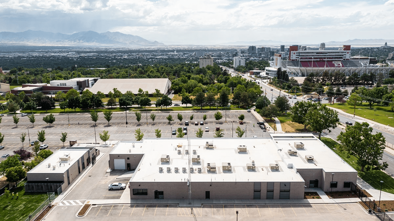 Back aerial view of University of Utah Public Safety Building building and parking lot.